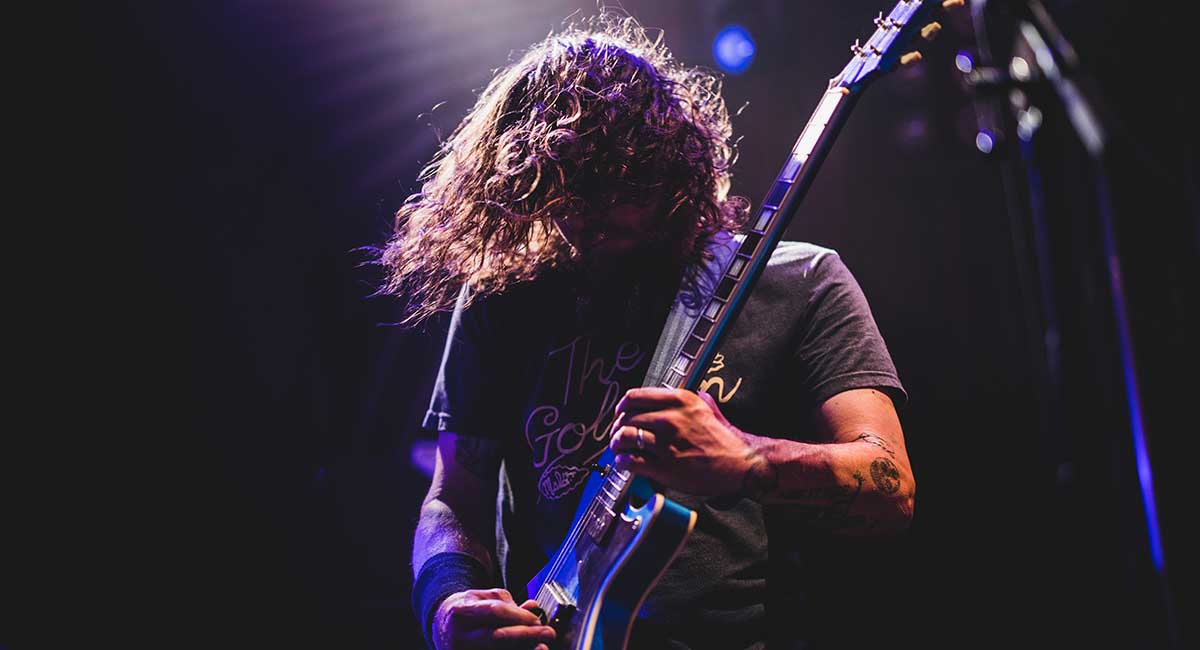 a guitarist playing his guitar on a huge stage