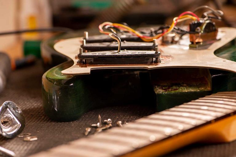 An electric guitar and its pickups being assembled