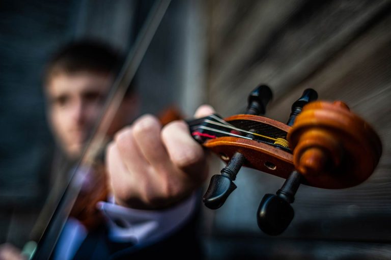 A violinist is playing his acoustic violin
