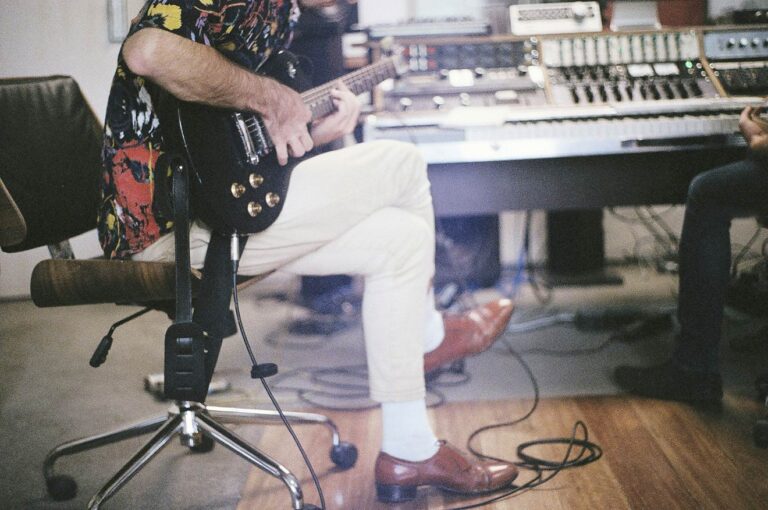 A guitarist is recording his music in a studio