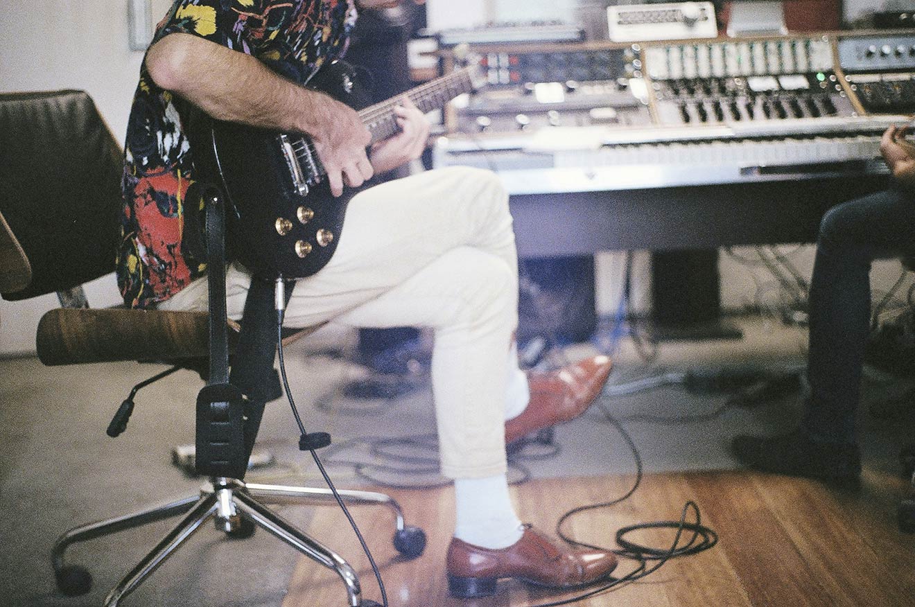 A guitarist is recording his music in a studio